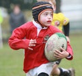 Boy with red jacket play rugby Royalty Free Stock Photo