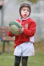 Boy with red jacket play rugby Royalty Free Stock Photo