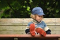 Boy in red rubber boots sitting on a rocking bench. Entangling Vines swing.