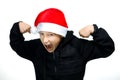 A boy in a red Santa hat shows threatening gestures and grinned