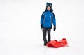 A boy with red sledge Royalty Free Stock Photo