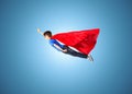 Boy in red superhero cape and mask flying on air Royalty Free Stock Photo