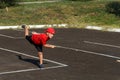 A boy in a red t-shirt and cap throws a wooden bat on the asphalt Royalty Free Stock Photo