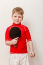 A boy in a red t-shirt holding a racket for table tennis Royalty Free Stock Photo