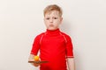 Boy in red t-shirt holding table tennis racket and ball