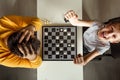 The boy rejoices in chess victory over his father. They play chess, family relationships, family. flat lay Royalty Free Stock Photo