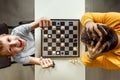 The boy rejoices in chess victory over his father. They play chess, family relationships, family. flat lay Royalty Free Stock Photo