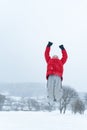 Boy rejoices in winter and snowy day. Child jumps with his hands up. Vertical frame