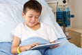 Boy Relaxing In Hospital Bed With Digital Tablet