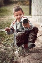 Boy remove sand from his shoe. Young boy trying to remove sand from his shoe