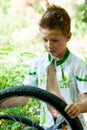 Boy repairing a bicycle wheel