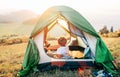 Boy rest in camping tent and enjoy with sunset light in mountain valley Royalty Free Stock Photo