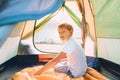 Boy resting in camping tent and enjoy with sunset light in mountain valley Royalty Free Stock Photo