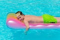 Boy resting on lilo in pool