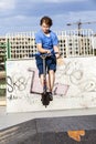 Boy rides his scooter at the skate park Royalty Free Stock Photo