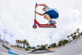 Boy rides his scooter at a skate park Royalty Free Stock Photo