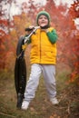 A boy rides a scooter in the autumn Park. Royalty Free Stock Photo