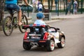 A boy rides a toy car in the Park