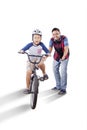 Boy riding a bike enthusiastically with his father