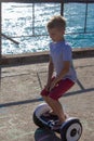 Boy riding an electric skateboard by the sea. Young man riding on the Hoverboard Royalty Free Stock Photo