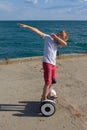 Boy riding an electric skateboard by the sea. Young man riding on the Hoverboard Royalty Free Stock Photo