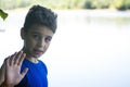 Boy on the riverbank giving the hand signal