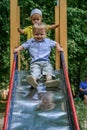 Boy rolls down a children`s slide in a park. Active lifestyle of Russian kids.