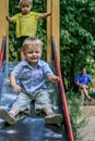 Boy rolls down a children`s slide in a park. Active lifestyle of Russian kids.