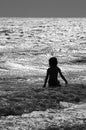 Boy in rough surf at the beach in black and white