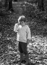 Boy in rubber boots walking in forest. Cute tourist concept. Forest school is outdoor education delivery model in which