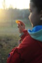 A boy in rubber boots walks through the forest and holds a magnifying glass in her hands, examines the stones, a mineral. Royalty Free Stock Photo