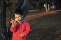 A boy in rubber boots walks through the forest and holds a magnifying glass in her hands, examines the stones, a mineral. Royalty Free Stock Photo