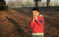 A boy in rubber boots walks through the forest and holds a magnifying glass in her hands, examines the stones, a mineral. Royalty Free Stock Photo