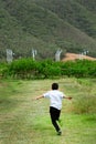 Boy running in field and wind turbines in backgroun Royalty Free Stock Photo