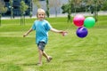 Boy running on a grass with balloons Royalty Free Stock Photo