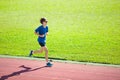 Teenager boy running on race track. Kids run. Royalty Free Stock Photo