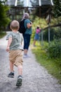 Boy running in a park with some people in blur background, vertical shot Royalty Free Stock Photo