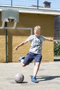 Kicking a ball in a street soccer pitch