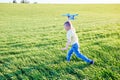 Boy runs with toy airplane in summer through field. Happy child running and playing with toy airplane outdoors. Boy dreams of Royalty Free Stock Photo