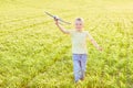 Boy runs with toy airplane in summer through field. Happy child running and playing with toy airplane outdoors. Boy dreams of Royalty Free Stock Photo