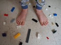The boy`s bare feet next to the scattered blocks