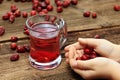 BoyÂ´s hand full of dried rosehips and glass of rose hip tea in the middle Royalty Free Stock Photo