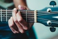 Boy`s hand strumming the strings on a guitar neck Royalty Free Stock Photo