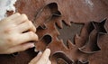 Boy's hands cutting different shapes out of rolled gingerbread dough Royalty Free Stock Photo