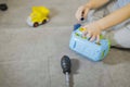 The boy`s hands with a screwdriver fixes a toy car-constructor