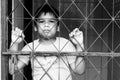 Boy sad standing alone behind jail Royalty Free Stock Photo