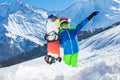 Boy in Santa Claus hat lift hand, smile stand with snowboard Royalty Free Stock Photo