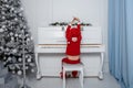 Boy in santa costume. Kid concept for merry Christmas and happy new year celebration. Small boy enjoys playing piano for Royalty Free Stock Photo