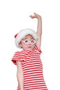 Boy in a Santa hat with an amazed face and a raised hand Royalty Free Stock Photo