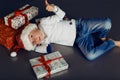 Boy in Santa hat posing with a lot of Christmas presents Royalty Free Stock Photo